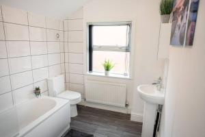 a white bathroom with a toilet and a sink at *Cosy home with parking for you* in Derby
