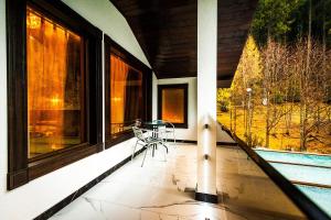 a balcony with a chair and a large window at Hotel Lacu Rosu in Lacu Rosu