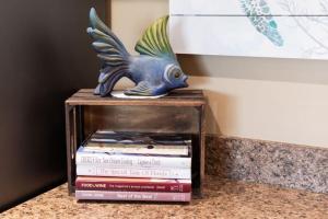 a statue of a fish sitting on top of books at Cozy Casita Beach Escape 850 A1A Unit 90 in St. Augustine