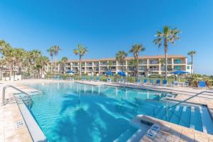 a large swimming pool with a resort in the background at Cozy Casita Beach Escape 850 A1A Unit 90 in St. Augustine