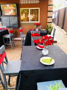 una mesa con servilletas rojas y flores en la parte superior en Pals Inn, en Busia