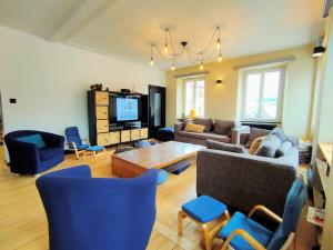 a living room with a couch and a table and chairs at Lancre / Maison kids-friendly en Alsace in Lutzelhouse +59 photos