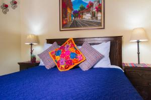 ein Schlafzimmer mit einem blauen Bett mit Kissen darauf in der Unterkunft Hostal Antigua in Antigua Guatemala