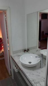 La salle de bains est pourvue d'un lavabo et d'un miroir. dans l'établissement Brandão House, à Caparica