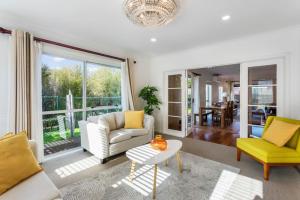 a living room with a couch and a table at 5-Bedroom Gem - Parking - Sandringham-Mount Eden in Auckland