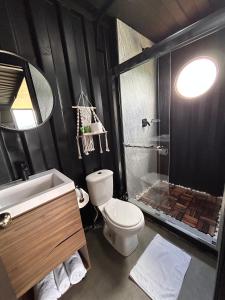 uma casa de banho com um chuveiro, um WC e um lavatório. em Nomada Republic Hotel El valle em Antón