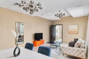 a living room with a couch and a tv at BellaVista - Spectacular - 2 BR Penthouse - Boulevard Central - Panoramic Terrace & Burj Khalifa View in Dubai