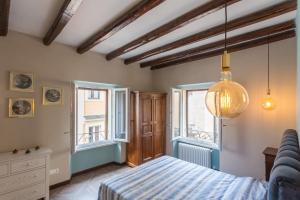 ein Schlafzimmer mit einem Bett und zwei Fenstern in der Unterkunft Frangipane 31 Monti Terrace in Rom
