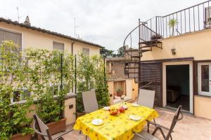 eine Terrasse mit einem gelben Tisch und Stühlen sowie ein Gebäude in der Unterkunft Frangipane 31 Monti Terrace in Rom