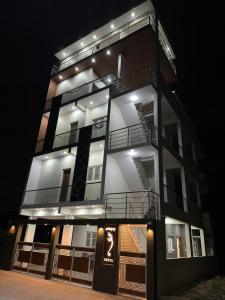 wysoki budynek z oświetleniem w nocy w obiekcie DEEYA Guest House w mieście Mysuru