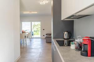 a kitchen with a counter and a living room at La Gemma sul Lago in Calceranica al Lago