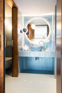 uma casa de banho azul com um lavatório e um espelho em Hotel Aare Thun em Thun