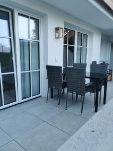 a black table and chairs on a patio with windows at Feine Bleibe in Eben im Pongau