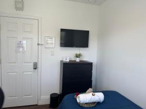 a bedroom with a bed and a tv on a wall at Cozy Private bedrooms Kitchen Wifi in Englewood
