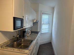 a kitchen with a sink and a tv on a counter at Cozy Private bedrooms Kitchen Wifi in Englewood