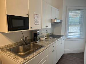 a kitchen with a sink and a microwave at Cozy Private bedrooms Kitchen Wifi in Englewood
