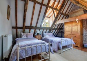 2 camas en un dormitorio ático con vigas de madera en Reclaim Cottage en Colkirk
