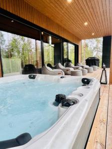 a large hot tub in a room with windows at Villa Aurinkorinne Himos in Jämsä