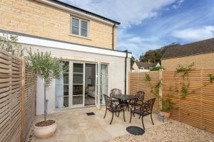 a patio with a table and chairs and a fence at Harpers Yard - 30 Chipping Norton in Chipping Norton