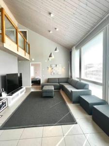 uma sala de estar com um sofá e uma televisão de ecrã plano em Villa Himalaja Himos em Jämsä