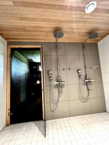 La salle de bains est pourvue d'une douche avec des tuyaux sur le mur. dans l'établissement Villa Himalaja Himos, à Jämsä
