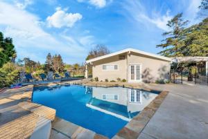 a home with a swimming pool and a house at Modern Family Farmhouse with Pool, Jacuzzi, Putting Green, Treehouse, Bocce and more in Thousand Oaks