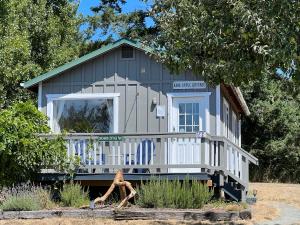 une petite maison bleue avec une terrasse couverte et une chaise dans l'établissement Deer Harbor Inn, à Deer Harbor