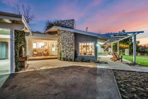 a house with a stone facade with a patio at Modern Family Farmhouse with Pool, Jacuzzi, Putting Green, Treehouse, Bocce and more in Thousand Oaks