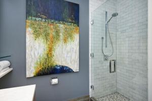 un bagno con un dipinto sul muro accanto a una doccia di Independence Square 212, Studio with Beautiful Finishes. A+ Location in Downtown Aspen ad Aspen