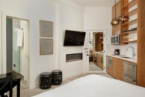 阿斯潘Independence Square 212, Studio with Beautiful Finishes. A+ Location in Downtown Aspen的白色的客房设有床、电视和厨房 更多7张照片
