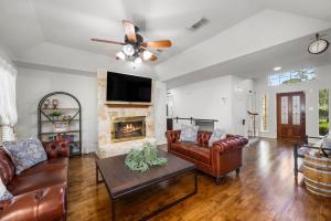 a living room with leather furniture and a fireplace at 5BR Train Theme Heated Pool Hot Tub EV BBQ in Spring