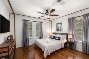 a bedroom with a bed and a ceiling fan at 5BR Train Theme Heated Pool Hot Tub EV BBQ in Spring +37 photos