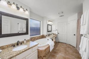 a bathroom with a tub and a sink and a mirror at 5BR Train Theme Heated Pool Hot Tub EV BBQ in Spring