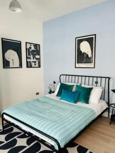 a bedroom with a bed with blue and white pillows at Elegant 1st Floor 1BR Belsize Park Apartment in London