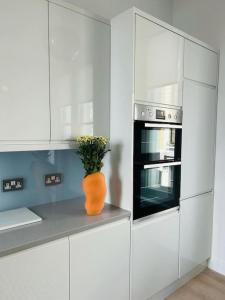 un vaso arancione seduto su un bancone in cucina di Elegant 1st Floor 1BR Belsize Park Apartment a Londra