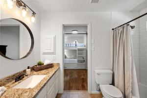 a bathroom with a sink and a toilet and a mirror at 5BR Train Theme Heated Pool Hot Tub EV BBQ in Spring