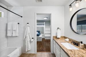 a white bathroom with a tub and a sink at 5BR Train Theme Heated Pool Hot Tub EV BBQ in Spring