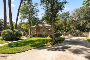 a house with palm trees and a driveway at 5BR Train Theme Heated Pool Hot Tub EV BBQ in Spring