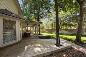 a porch of a house with a wooden deck at 5BR Train Theme Heated Pool Hot Tub EV BBQ in Spring