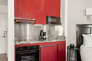 una cocina con armarios rojos y fregadero en Independence Square Unit 303, Corner Studio with Premier Finishes, Downtown Location en Aspen