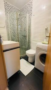 a bathroom with a shower toilet and a washing machine at Skopje Centre apartment in Skopje
