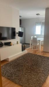 uma sala de estar com uma televisão de ecrã plano e uma mesa em Skopje Centre apartment em Skopje