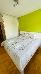 um quarto com uma cama branca e uma parede verde em Skopje Centre apartment em Skopje