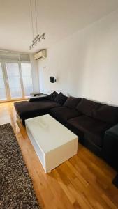 a living room with a black couch and a white table at Skopje Centre apartment in Skopje
