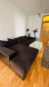 uma sala de estar com um sofá de couro castanho num quarto em Skopje Centre apartment em Skopje