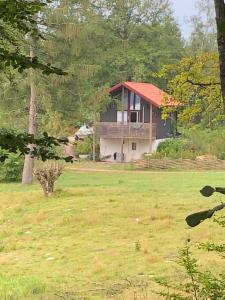 a house with a red roof in a field at Joarsbo, Stuga 2, Gårdsstugan in Kalv