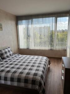 a bedroom with a bed and a large window at Апартамент Комфорт, близо до Летището in Sofia