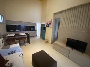 sala de estar con sofá, TV y mesa en Vilas Na Praia Residence Condomínio en Canoa Quebrada