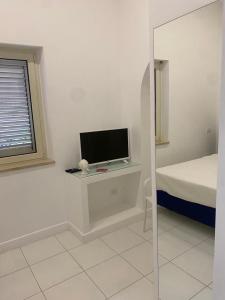 1 dormitorio con escritorio, TV y cama en Abagnale Home Sorrento en Sorrento
