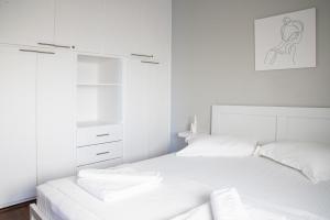 a white bedroom with two beds with white cabinets at Chios BnB in Chios